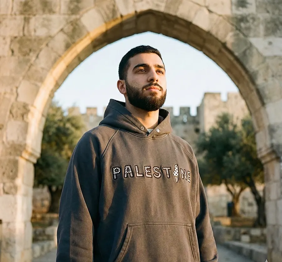 A Qordova heavyweight hoodie worn under a stone arch